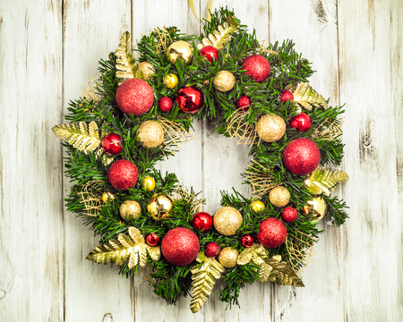 Advent christmas wreath with decorations hanging on wooden doorの写真素材