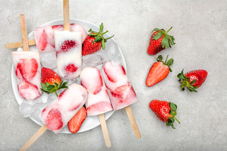 Strawberry popsicles with yogurt and fruits, frozen homemade ice popsの写真素材
