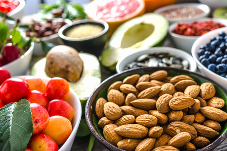 Bowl with almonds and other superfoods on table. Breakfast containing healthy food, organic vegetarian nutrition like nuts and fruitsの写真素材