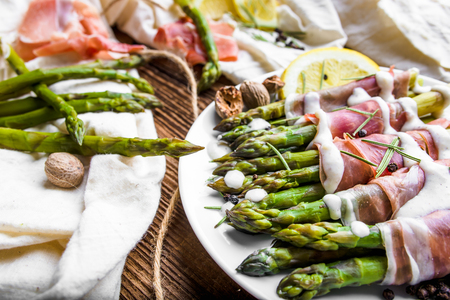 Italian dish with cooked asparagus wrapped with prosciutto hamの写真素材
