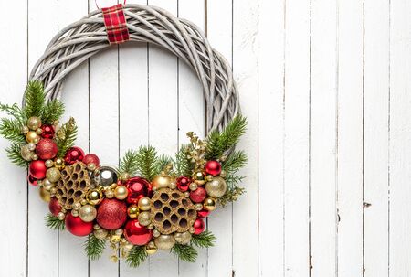 Christmas wreath on wood background with golden and red baubles and and christmas treeの写真素材