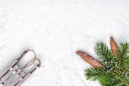 Christmas background with snow, sleigh, christmas pine branch and pine cones, flat lay, top viewの写真素材