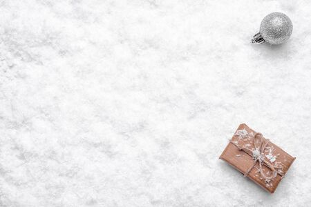 Christmas white background with gift box and christmas ornament on fresh snow surface, copy spaceの写真素材