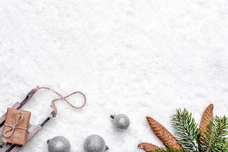 Christmas composition with snow, christmas gift, ornaments, and green pine branch with cones, flat...
