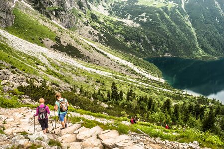 TATRA, POLAND - JULY 4: The tourists on mountain trail to Morskie Oko and Czarny Staw at the Rysy on JULY 4, 2015 in the Tatra National Park, Poland. Popular for outdoor activities and trekking.のeditorial素材