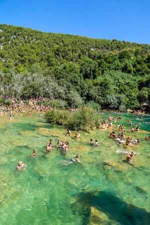 KRKA NATIONAL PARK, CROATIA - AUG 19, 2019: People swim in Krka River over Skradinski Buk in Croatia, Waterfall in Krka National Parkのeditorial素材