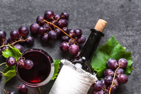 Bottle of wine and glass of red wine with grapesの写真素材