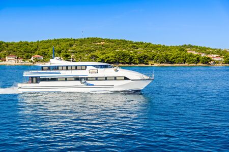Beautifull seascape with small ship - motor boat or luxury yacht cruising on the sea at the coast of island on Adriatic Sea in Croatia, green paradise, islands Kornatiの写真素材