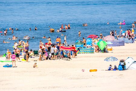 LEBA, POLAND - JUNE 30, 2019: Crowd of people on the beach, summer vacation concept, sunbathing and bathing in the sea under azure skyのeditorial素材