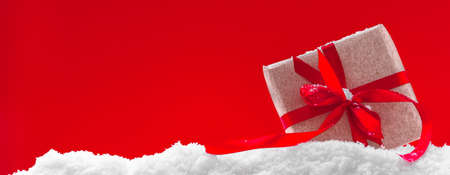 Christmas banner, red background with christmas gift and snowの写真素材