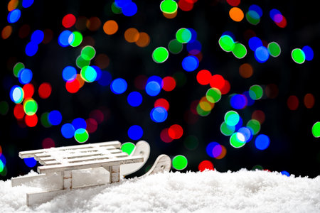 Christmas lights background with snow and sledの写真素材