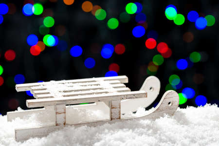 Christmas lights background with snow and sledgeの写真素材
