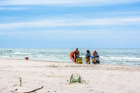 LEBA, POLAND - JULY 31, 2016: Unidentified family walking on the beach in the summer holiday enjoying good weather. Walk along sea shore.のeditorial素材