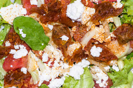 Salad with vegetables with feta cheese and sun-dried tomatoes, macro close-up, food backgroundsの写真素材