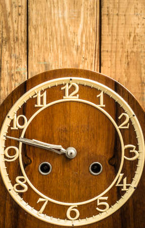 Vintage clock on wooden wall background. Concept of the passage of time.の写真素材