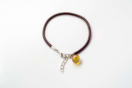 Close-up of handmade bracelet made with brown leather straps and crystal glass isolated on white background, simple made.の写真素材