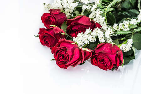 Flowers background with bouquet of red roses on white background useful as valentine card, greeting card, wedding invitation or anniversary card.の写真素材
