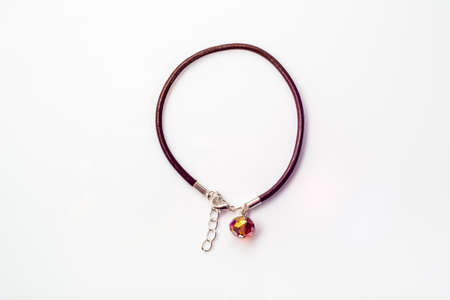 Close-up of handmade bracelet made with brown leather straps and crystal glass isolated on white background, top view, simple made.の写真素材