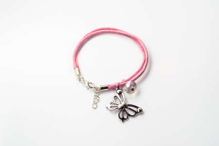 Close-up of handmade bracelet made with pink leather, crystal glass and butterfly pendant isolated on white background.の写真素材