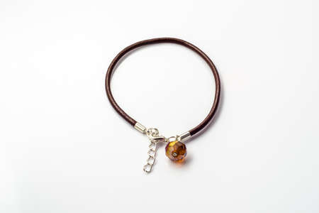Close-up of handmade bracelet made with brown leather straps and crystal glass isolated on white background, simple made.の写真素材
