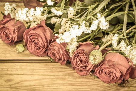 Vintage roses on wooden background useful as wedding card, valentines card or anniversary card, floral frame with copy spaceの写真素材