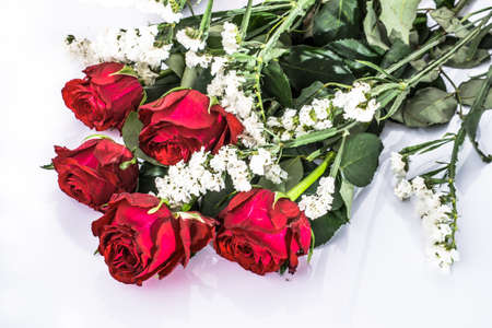 Flowers background with bouquet of red roses on white background useful as valentine card, greeting card, wedding invitation or anniversary card.の写真素材