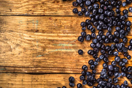 Blueberries picked in forest located on wood background, close-up, background textureの写真素材
