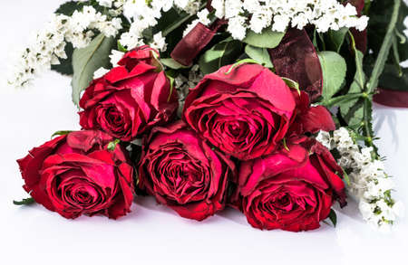 Flowers background with bouquet of red roses on white background useful as valentine card, greeting card, wedding invitation or anniversary card.の写真素材