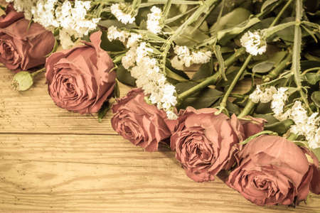 Vintage roses on wooden background useful as wedding card, valentines card or anniversary card, floral frame with copy spaceの写真素材