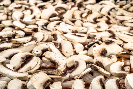 Mushrooms champignon sliced and arranged on pizza margherita for background or texture, shallow depth of field, fast food preparation close-up.の写真素材