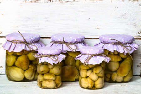 Boletus mushrooms marinated in jars on wood background.の写真素材