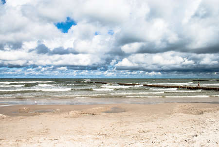 Landscape of beach and sea with waves, cloudy sky. Baltic sea coast near Leba in Poland.の写真素材