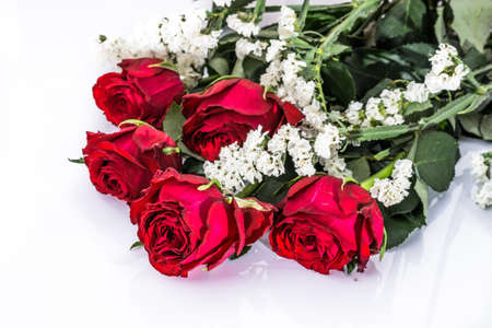 Flowers background with bouquet of red roses on white background useful as valentine card, greeting card, wedding invitation or anniversary card.の写真素材