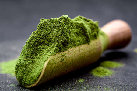 Green tea, matcha. Powdered young barley or wheat grass on wooden scoop. Detox superfood concept.の写真素材