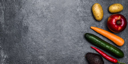 Healthy food background. Healthy vegetarian food. Vegetables and fruits on black stone. Clean vegetarian eating concept.の写真素材