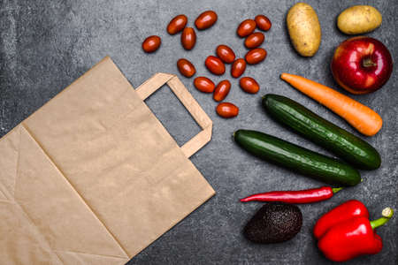 Healthy food background. Delivery of healthy vegetarian food in bag. Vegetables and fruits on black stone. Shopping food in supermarket. Clean vegetarian eating concept.の写真素材