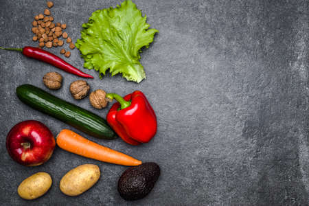 Healthy food background. Healthy vegetarian food. Vegetables and fruits on black stone. Clean vegetarian eating concept.の写真素材
