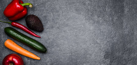 Healthy food background. Healthy vegetarian food. Vegetables and fruits on black stone. Clean vegetarian eating concept.の写真素材