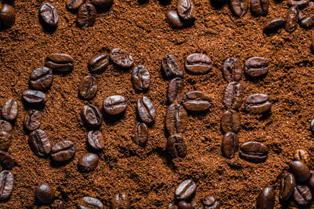 Background of coffee. Sign made of freshly roasted beans arranged on powdered coffee, texture.の写真素材