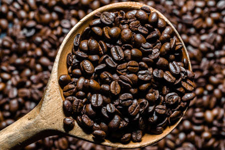Freshly roasted coffee beans in spoon. Coffee background.の写真素材