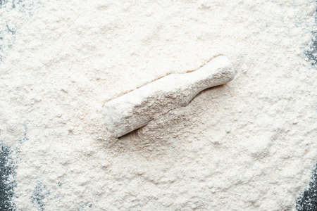Baking background with flour in wooden scoopの写真素材