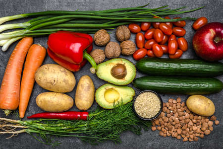 Healthy food background. Healthy vegetarian food. Vegetables and fruits on black stone. Clean vegetarian eating concept.の写真素材