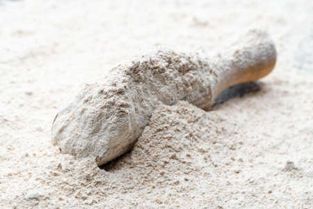 Background with flour in wooden scoopの写真素材
