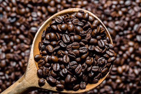 Freshly roasted coffee beans in wooden scoop. Black coffee background.の写真素材
