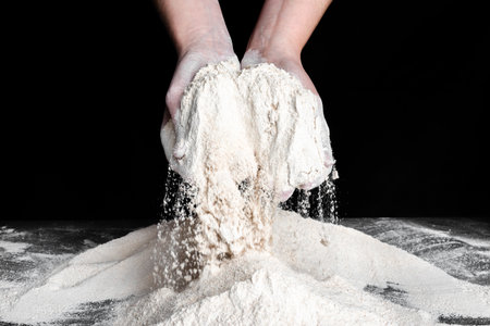Baker with flour in hands. Preparing dough for bread. Baking concept.の写真素材
