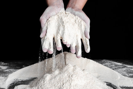 Baker with flour in hands. Preparing whole grain flour for bread. Baking concept.の写真素材