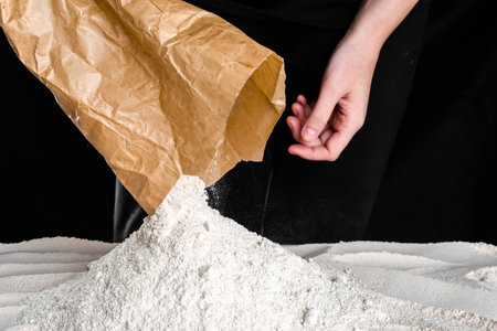 Baker pouring flour on the table. Preparing dough for bread or pizza. Baking concept.の写真素材