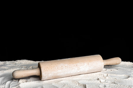 Rolling pin and flour on a dark background.の写真素材