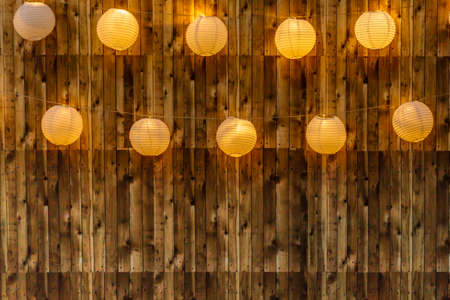 patterns and yellow lighted paper lanterns on wood paneling