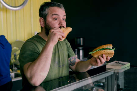 the hungry man who eats a sandwichの写真素材